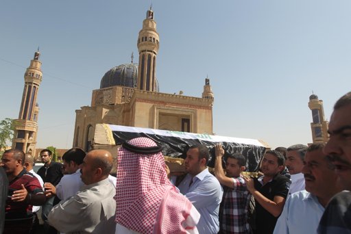  Iraqi mourners carry a coffin past the Baghdad’s Umm al-Qura mosque