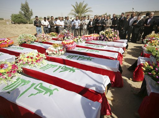  Officials  –  residents pray over coffins bearing the remains of 200 people in Kerbala