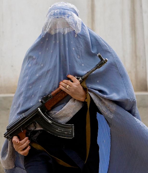 A woman wearing a burka holds a gun .File Photo.