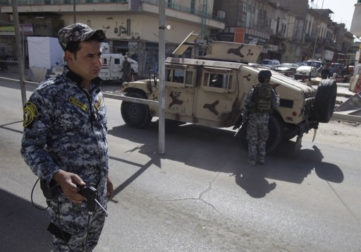  An Iraqi police officer uses a detector at a checkpoint in central Baghdad, Iraq, Sunday, Oct. 23, 2011