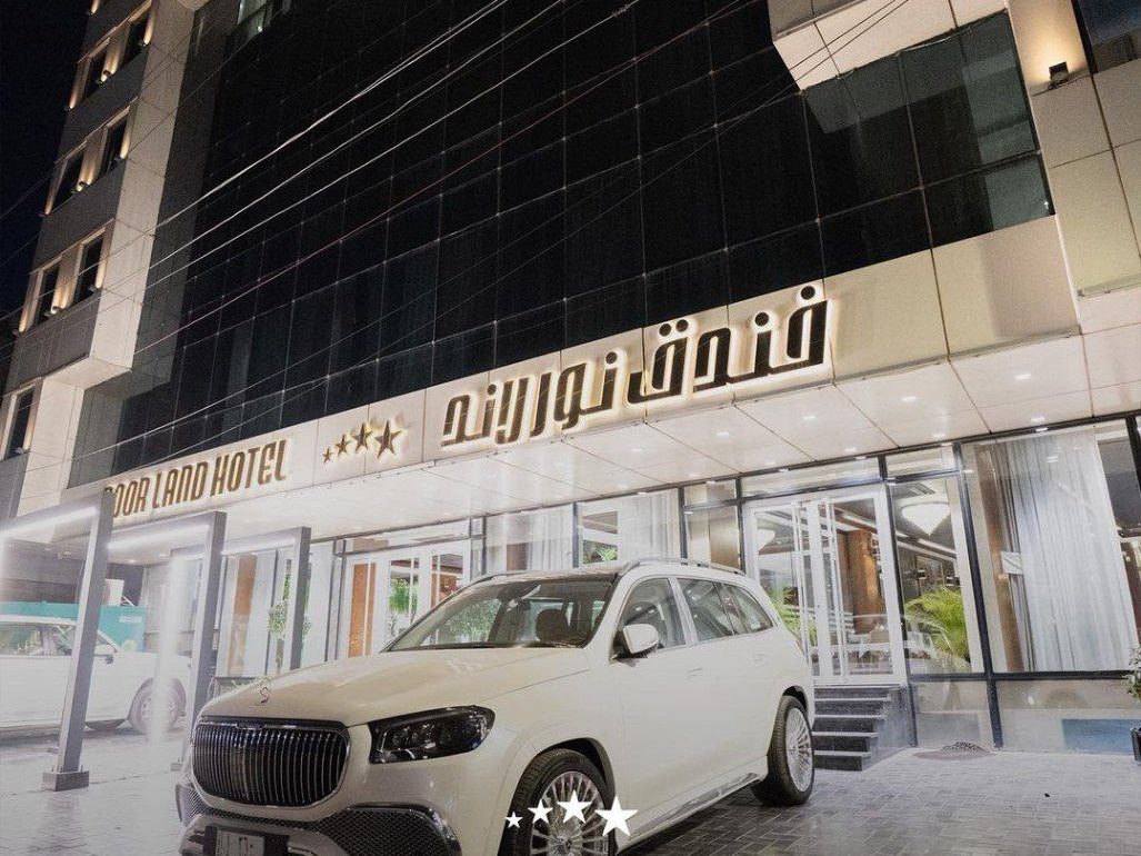 Noorland hotel at night with a Mercides car parked infront of it.