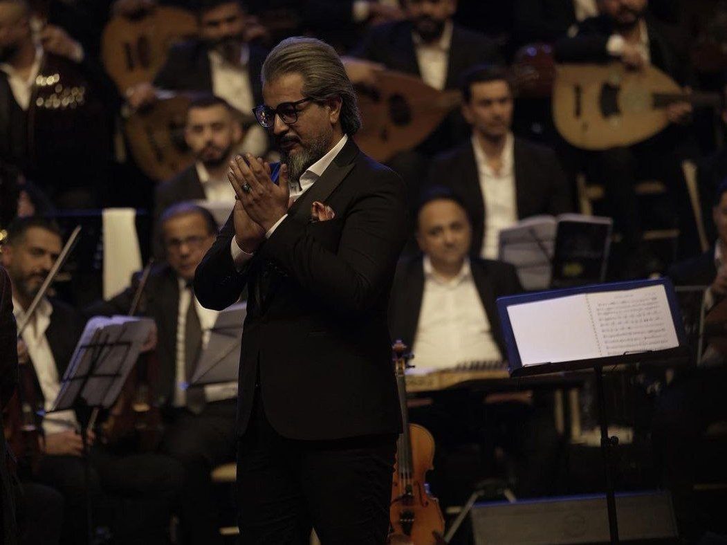 Mustafa Zair the leader of an Iraqi musical band is standing for the audience